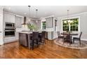 Bright, open kitchen featuring granite countertops, an island with seating, and a breakfast nook with windows at 105 Everam Ct, Chapel Hill, NC 27516