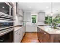 Modern kitchen with stainless steel appliances, granite countertops, gray cabinets, and hardwood flooring at 105 Everam Ct, Chapel Hill, NC 27516