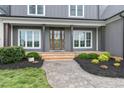 Inviting front porch with stained wood columns and walkway with manicured landscaping at 106 Garrison Farm Rd, Mebane, NC 27302