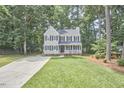 Traditional two-story home featuring a lush green lawn and a welcoming facade surrounded by mature trees at 106 Rock Nest Ct, Morrisville, NC 27560