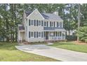 A two-story home with a well-maintained lawn and charming front porch, enhanced by mature trees at 106 Rock Nest Ct, Morrisville, NC 27560