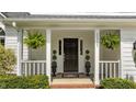 Inviting front porch with hanging ferns and manicured shrubbery at 12117 Inglehurst Dr, Raleigh, NC 27613