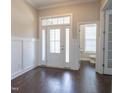 Bright foyer with wood floors, decorative wall trim, and a view into the adjacent powder room at 1217 Great Egret Way, Durham, NC 27713