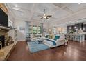 Bright living room featuring a coffered ceiling, hardwood floors, large windows, and an open layout at 12216 Kyle Abbey Ln, Raleigh, NC 27613