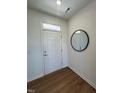 A bright entryway features a round mirror and a white door leading to other parts of the home at 125 Fraiser Fir Way, Lillington, NC 27546
