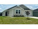 Inviting one-story home featuring a well-maintained lawn and garden beds, complemented by a two-car garage at 125 Fraiser Fir Way, Lillington, NC 27546