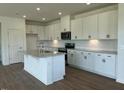 Modern kitchen featuring white cabinets, stainless steel appliances, gray countertops, and a center island at 125 Fraiser Fir Way, Lillington, NC 27546
