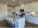 Bright kitchen featuring a large island, granite countertops and modern white cabinets at 125 Fraiser Fir Way, Lillington, NC 27546