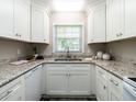 Bright kitchen featuring granite countertops, sleek white cabinets, and stainless steel appliances at 1612 Bethlehem Rd, Knightdale, NC 27545