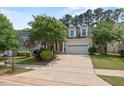 Inviting curb appeal with lush lawn, mature trees, and a two-car garage at 1612 Old Bramble Ln, Fuquay Varina, NC 27526