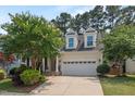 Traditional home with dormer windows, a two-car garage, and a beautifully landscaped front yard at 1612 Old Bramble Ln, Fuquay Varina, NC 27526