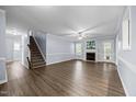 Open-concept living room featuring hardwood floors, gray walls, a fireplace and a staircase to the second floor at 191 Bridle Dr, Angier, NC 27501