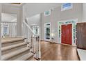 Grand foyer featuring hardwood floors, a staircase, and a bright red front door at 2224 Narrawood St, Raleigh, NC 27614