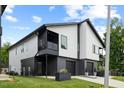 Modern home with a two-car garage, sleek black and white siding, and a covered balcony at 2225 Millbank Village Ct # 101, Raleigh, NC 27610