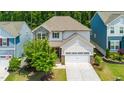 An aerial view of a well-maintained two-story house with a manicured lawn and an attached two-car garage at 2619 Bordwell Grant Dr, New Hill, NC 27562
