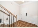 Welcoming entryway with a staircase, wood floors, and white wainscoting for a classic touch at 2619 Bordwell Grant Dr, New Hill, NC 27562