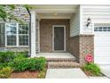 Inviting front porch with brick columns, offering a warm welcome to this charming home at 2619 Bordwell Grant Dr, New Hill, NC 27562