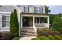 Inviting front porch with stone steps, decorative columns, and a charming entrance to the home at 2661 Silver Bend Dr, Apex, NC 27539