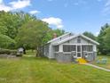 Inviting home with well-kept landscaping, featuring a screened porch, yellow stairs and outdoor seating at 2815 Orange Grove Rd, Hillsborough, NC 27278