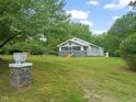 Quaint home featuring mature trees and a well-manicured lawn, with a glimpse of the charming front porch at 2815 Orange Grove Rd, Hillsborough, NC 27278