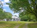 Well-maintained home surrounded by lush greenery, showcasing a lovely screened porch and ample yard space at 2815 Orange Grove Rd, Hillsborough, NC 27278