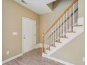 Inviting foyer area with staircase, light walls, and door at 2845 Bennington Dr, Clayton, NC 27520
