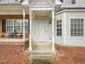 A close-up of the townhouse entryway, showcasing the covered porch and the front door with sidelight at 2845 Bennington Dr, Clayton, NC 27520