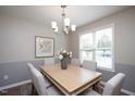 Well-lit dining room with a modern chandelier, table set for six, and natural light at 308 E Quailwood Dr, Fuquay Varina, NC 27526
