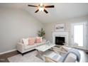 Bright living room featuring a fireplace, ceiling fan, and a comfortable sofa with stylish pillows at 308 E Quailwood Dr, Fuquay Varina, NC 27526