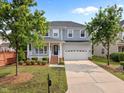 Beautiful two-story home with a front porch, attached garage, and lush green lawn with mature trees at 324 Farrow Glen Loop, Cary, NC 27519