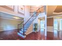 Grand foyer showcasing beautiful hardwood floors, a staircase with rod iron spindles and tasteful wall decor at 3408 Mount Pisgah Way, Cary, NC 27519
