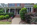 Inviting front porch with stately columns and manicured hedges, creating a welcoming entrance to this brick home at 3408 Mount Pisgah Way, Cary, NC 27519