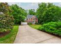 Traditional brick home with a long driveway and lush green landscaping at 3908 Sterling Ridge Ln, Durham, NC 27707