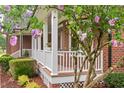 Charming porch with blooming tree offering a cozy and inviting view at 3912 Kildrummy Dr, Durham, NC 27705