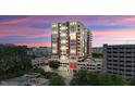 Exterior view of modern multi-story building with parking and greenery around it at dusk at 400 W North St # 604, Raleigh, NC 27603