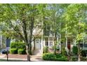 Inviting two-story townhome with a charming front porch, lush greenery, and a well-manicured lawn at 408 Heritage Village Ln, Apex, NC 27502