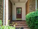 Charming covered front porch with brick flooring and access to the front door at 4204 Thetford Rd, Durham, NC 27707