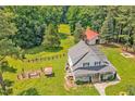 Aerial view of a beautiful white farmhouse with a large yard and surrounding trees at 4702 Pleasant Green Rd, Durham, NC 27705