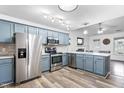 Modern kitchen featuring stainless steel appliances, custom blue cabinetry, and stylish backsplash at 50 Rainwood Ct, Louisburg, NC 27549