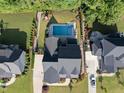 Aerial view of the property showcasing a backyard oasis with pool, patio, and manicured landscaping at 517 Myrna Ln, Wake Forest, NC 27587