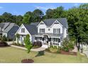 Beautifully landscaped home with lush lawn, mature trees, and inviting front porch with decorative details at 517 Myrna Ln, Wake Forest, NC 27587