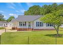 Charming single-story home featuring a well-manicured lawn, quaint front porch, and a detached garage at 5328 Trackway Dr, Knightdale, NC 27545