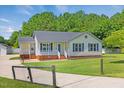 Charming single-story home with blue shutters, a quaint front porch, and well-maintained landscaping at 5328 Trackway Dr, Knightdale, NC 27545
