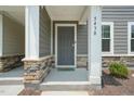 Inviting front entrance with a stone-accented porch and craftsman-style door at 5430 Crescent Square St, Raleigh, NC 27616