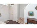 Bright entryway with white doors, hardwood floors, and carpeted stairs, creating a clean and inviting welcome at 610 Walnut Woods Dr, Morrisville, NC 27560