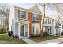 Two-story townhouse with a mix of gray siding and brick, featuring a well-manicured lawn at 610 Walnut Woods Dr, Morrisville, NC 27560