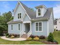 Beautiful blue home with a landscaped yard, white trim, and inviting front entrance at 622 Sunset Ave, Apex, NC 27502