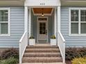 Inviting front entrance with brick steps, decorative plants, and charming overhead light fixture at 622 Sunset Ave, Apex, NC 27502