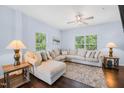 Bright living room features a neutral sectional, ceiling fan, and large windows at 6729 Osprey Landing Dr, Wendell, NC 27591