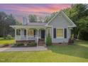 Charming single Gathering home with a well-maintained lawn and inviting front porch at sunset at 701 Creekside Dr, Clayton, NC 27520